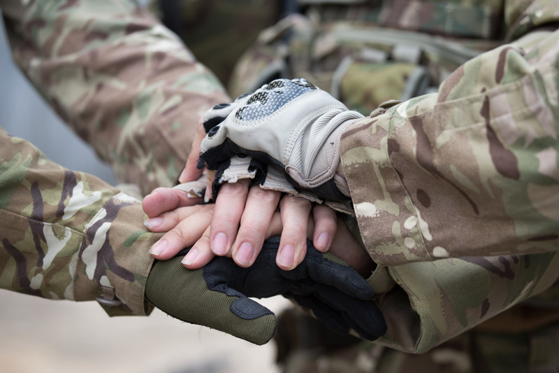 Soldiers in camouflage uniforms showing teamwork and leadership during military training and development for frontline services.